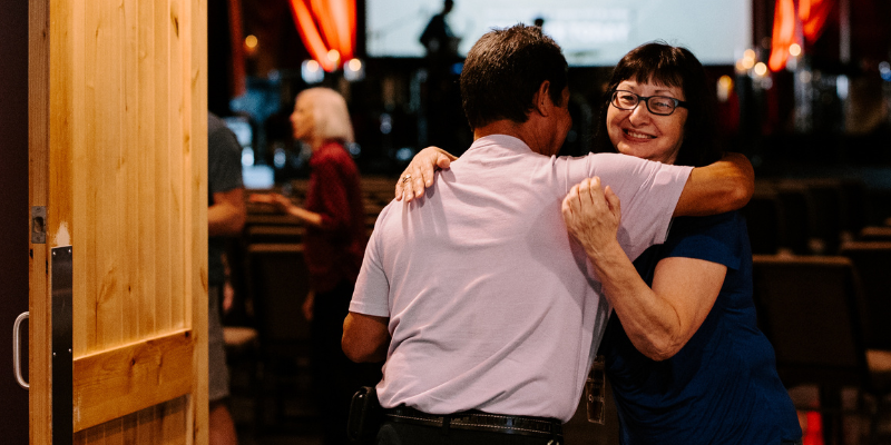 A person giving a side hug to another